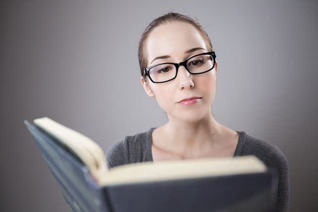 woman wearing glasses reading